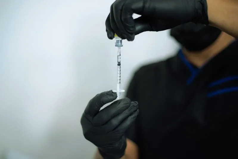 A provider preparing a syringe in a calm clinical setting